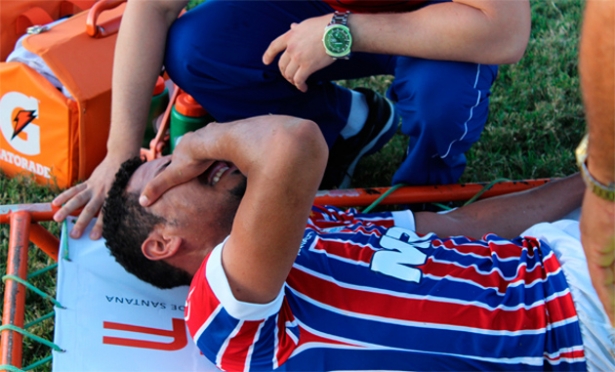  No treino de sexta, Hernane posou para o CORREIO segurando uma furadeira. Uma furadeira sem broca. Deu no que deu. O Brocador até teve chances no jogo de ontem contra o Bahia de Feira, mas desperdiçou todas, uma delas quase na pequena área. Para piorar tudo, ainda tropeçou sozinho, sofreu uma entorse no joelho esquerdo (com suspeita de lesão ligamentar) e está praticamente fora do Ba-Vi. Mesmo em um dia ruim, Hernane era quem mais se apresentava no ataque. Na melhor oportunidade, de bate-pronto, quase fura a rede adversária. O goleiro espalmou por cima da trave. “Consegui finalizar bem”, disse ele no intervalo, talvez esquecendo-se de que a bola não entrou. Minutos depois, livre entre os zagueiros, quase fez de cabeça. Hernane vai passar por exame para saber a gravidade do problema (Foto: Silvonei Viana) Passava dos 19 minutos quando, disputando uma bola, o artilheiro tricolor na temporada (oito gols) desabou no chão. O zagueiro adversário sequer tocou nele. O Brocador pisou em falso e já caiu com expressão de dor. Substituído por Jacó, saiu do gramado com uma bolsa de gelo e chorou quando conversou com os médicos. Clima de preocupação. A primeira análise foi de uma entorse. Será que ele joga o Ba-Vi? Era a pergunta que todos se faziam. Em entrevista para emissoras de rádio no estádio Pedro Amorim, em Senhor do Bonfim, o médico Rodrigo Daniel disse que havia suspeita de lesão ligamentar, mas o jogador ainda vai passar por avaliação. “Vai ser confirmada ou não no exame de imagem”. O técnico Doriva lamentou a contusão do seu principal jogador. “Ele é importantíssimo, tem feito a diferença não só dentro de campo, mas também fora. Nos surpreende muito o posicionamento dele no grupo”. Ciente de que vai ser difícil contar com o atleta para o clássico, agora torce para que não seja algo mais sério que comprometa o restante do ano. “Nossa torcida, oração e união é para que não seja nada, só um susto. Que ele possa se recuperar o mais rápido possível. Um jogador desse nível a gente não encontra no mercado. E ele está muito confiante, tem feito uma temporada brilhante, está motivado. Torcemos para que ele se recupere”, afirmou Doriva.